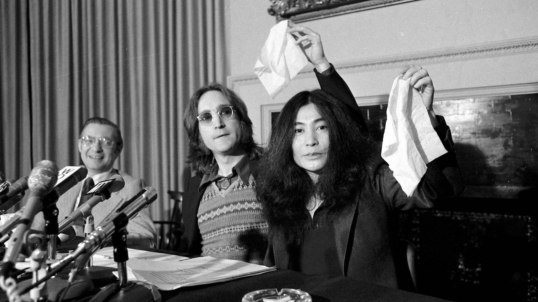 John Lennon and Yoko Ono at a press conference, holding up white handkerchiefs, announcing the founding of Nutopia.