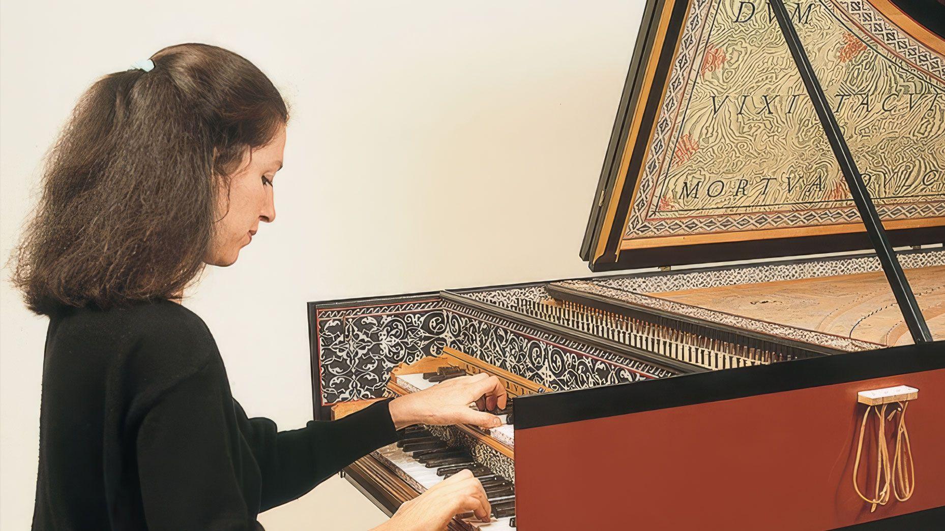 Maggie Cole playing a painted harpsichord.